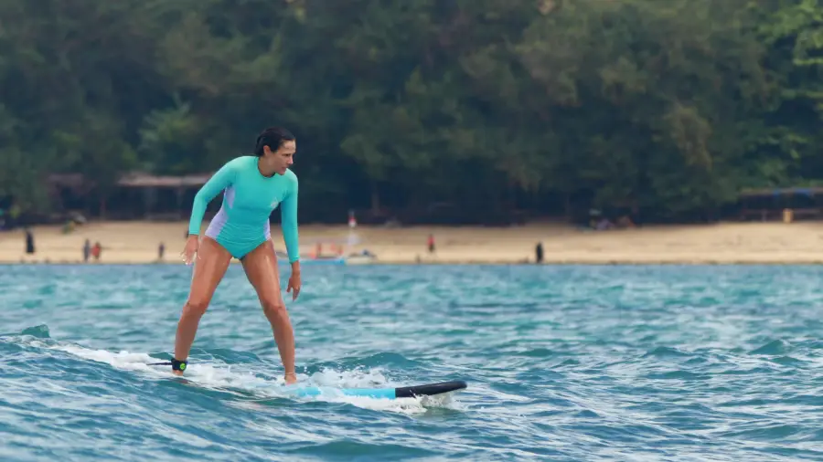 woman learn to stand on surfboard on kuta beach lombok