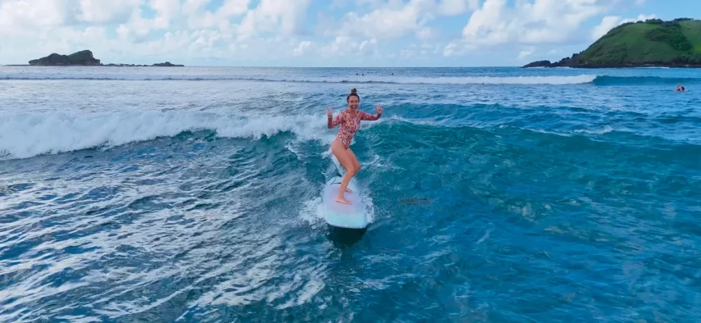 Surfer riding small wave at Tanjung Aan Lombok