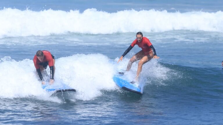 Surfwell guests riding the long left waves at Medewi Beach, Bali.