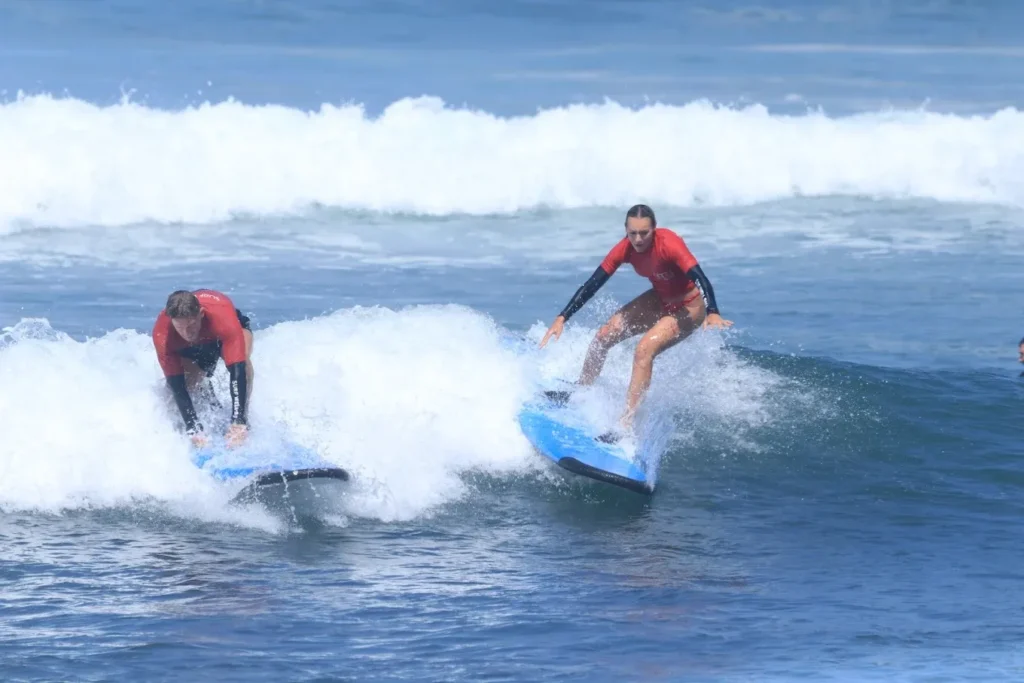 Beginner learning to surf in Canggu with soft top board