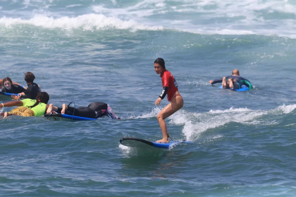 A happy Surfwell student successfully standing up on a wave during their very first private lesson in Bali.